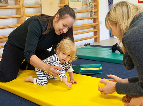 Zsofia working with a small boy crawling at Whoopsadaisy 